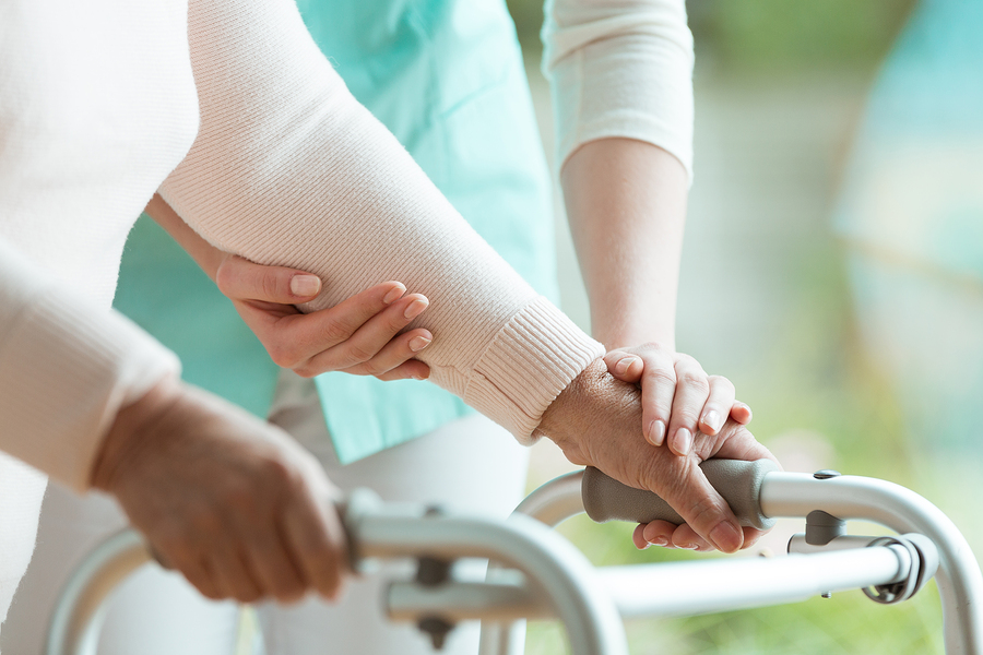 Closeup Of Senior Lady's Hands Holding A Walker And Helpful Nurs Closeup of senior lady's hands holding a walker and helpful nurse supporting her